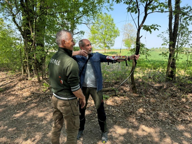 Un aspirante arciere che tira una freccia assistito da istruttore al campo base della compagnia 08cale